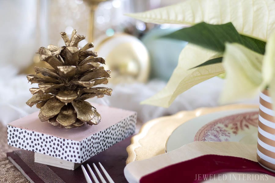 Pinecone dinner party|| THIS DINING ROOM! Looking for inspiration for a eclectic, chic, and glam Christmas? Jeweled Interiors, Holiday, Home Tour, Burgundy, cranberry, blush, Decor, Ideas, Tips, wreaths, Christmas, tree, decor, decorations, DIY, inspiration, red, maroon, wine, home tour, poinsettia, glam, chic, peach, gold, black, white, Panton, chairs, brass, chandelier, tablescape, pinecones