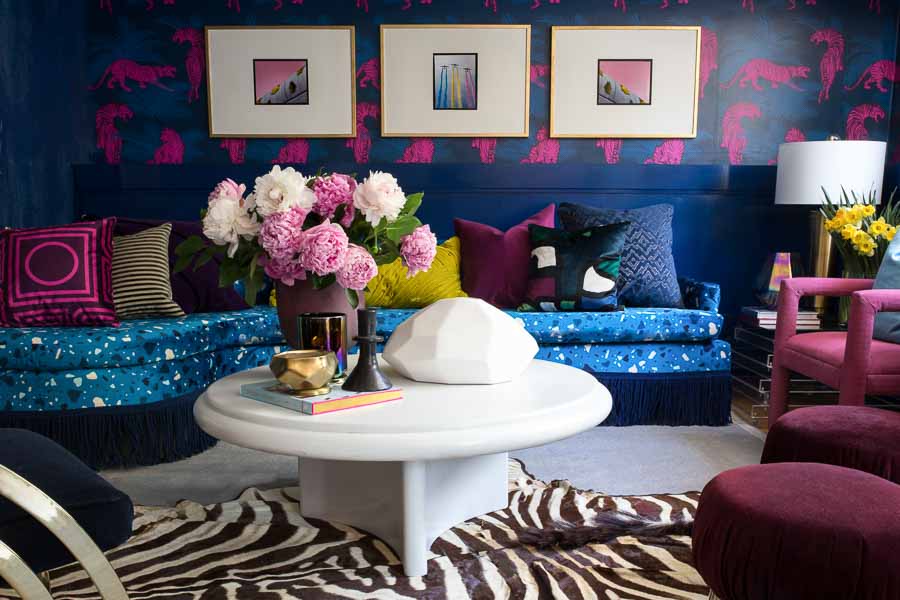 You have to see this amazing before and after transformation! I love the terrazzo blue sofa with blue fringe, peonies, Karl springer coffee table, the acid pink tiger wallpaper, zebra rug, chic living room and bright, bold color choices.