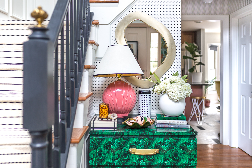 Check out this two story entryway reveal! Velvet Finishes Paint, Ikea stair runner, Hudson Valley lighting, Rye flush mount, black handrails, Simplimente Puntos wallpaper, Milton and King, black and with stairs, jewel marlowe, jeweled interiors, entryway, reveal, choose your own adventure refresh, Metrie moulding, zebra rug, leopard chair, tassel fringe on runner, brass stair finials. panel moulding, french apartment style, spoonflower, malachite, art deco, fringe stool, pink kitchen