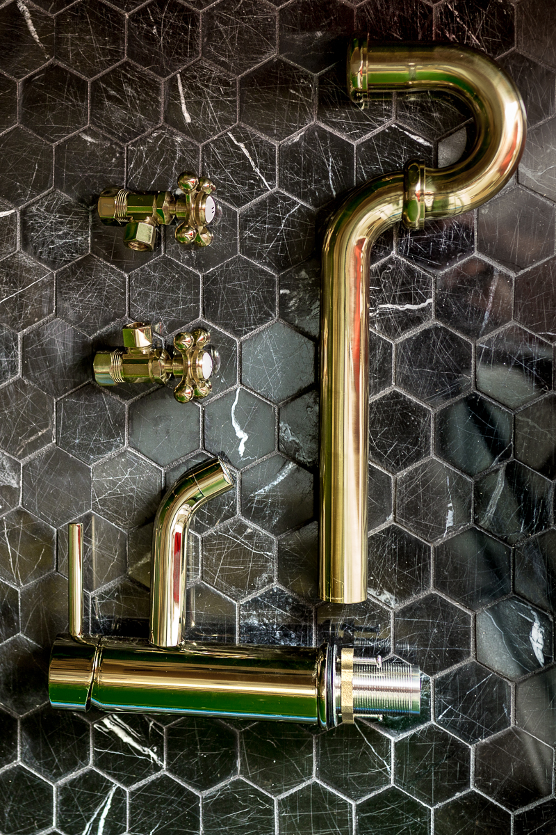 brass faucet, black marble tile, brass trapping, brass plumbing