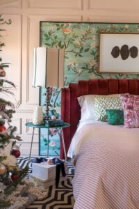 Bedroom with Christmas tree and floral wallpaper.