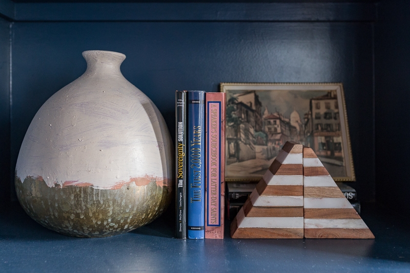 Jeweled Interiors Stiffkey Blue, Farrow and Ball, office, with built in shelves, and organization boxes, and antique desk and chair, wallpapered ceiling, oversized art