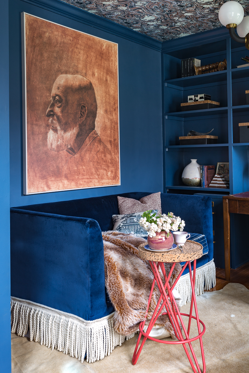 Jeweled Interiors Stiffkey Blue, Farrow and Ball, office, with built in shelves, and organization boxes, and antique desk and chair, wallpapered ceiling, oversized art