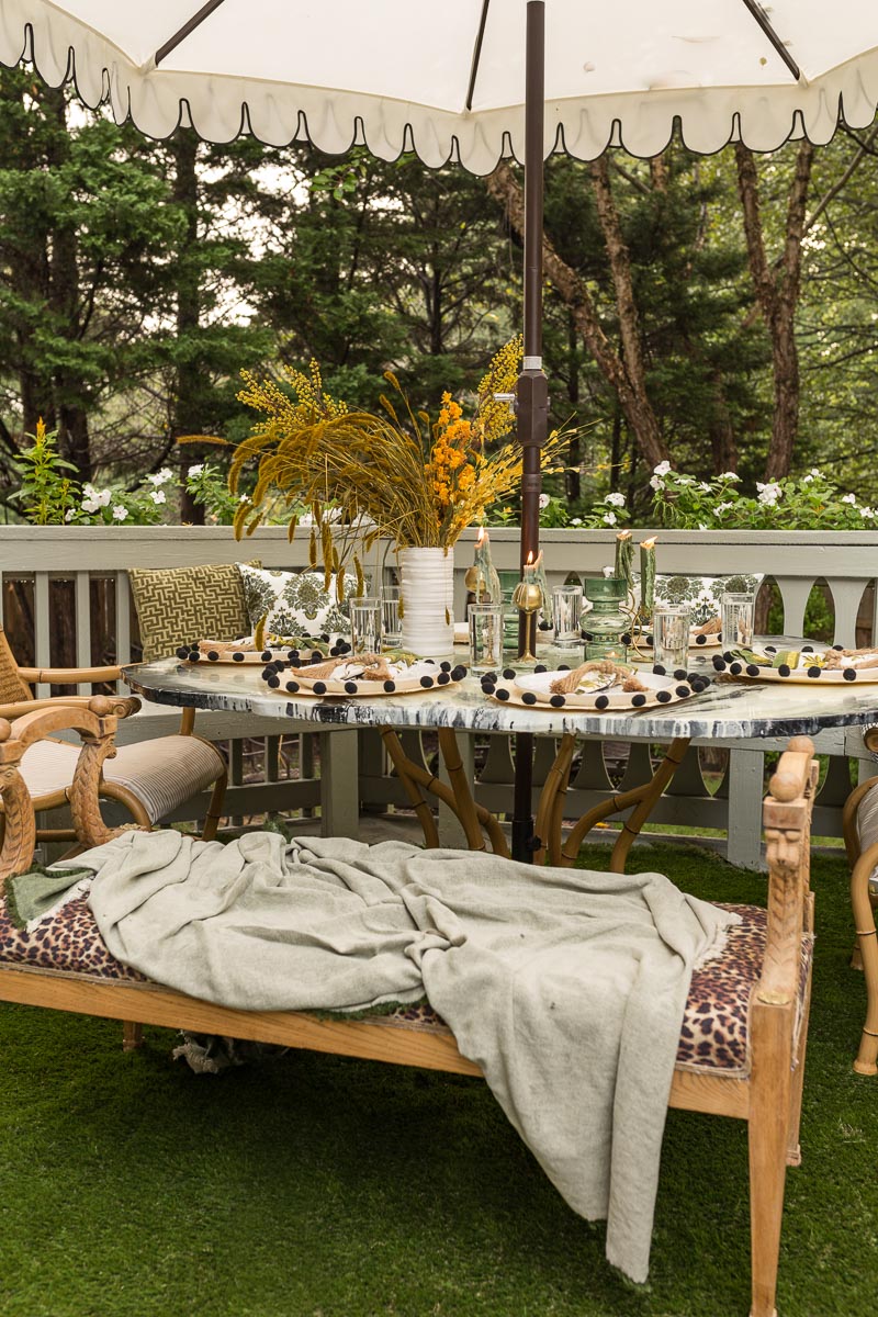 patio decorating ideas, patio ideas, artificial grass rug, antique bench, agate table, deck, entertaining, fall, bamboo chair, black and white umbrella 