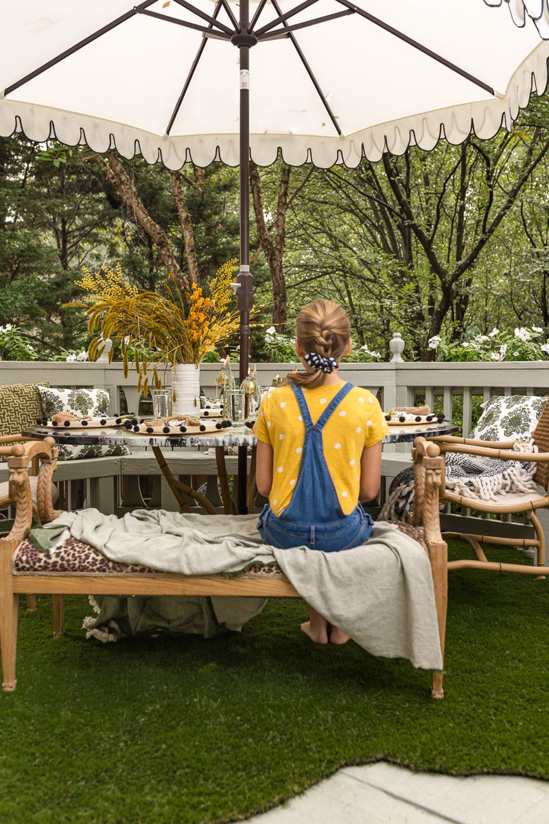 patio decorating ideas, patio ideas, artificial grass rug, antique bench, agate table, deck, entertaining, fall, bamboo chair, black and white umbrella 