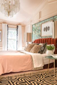 Elegant bedroom with patterned decor and chandelier.