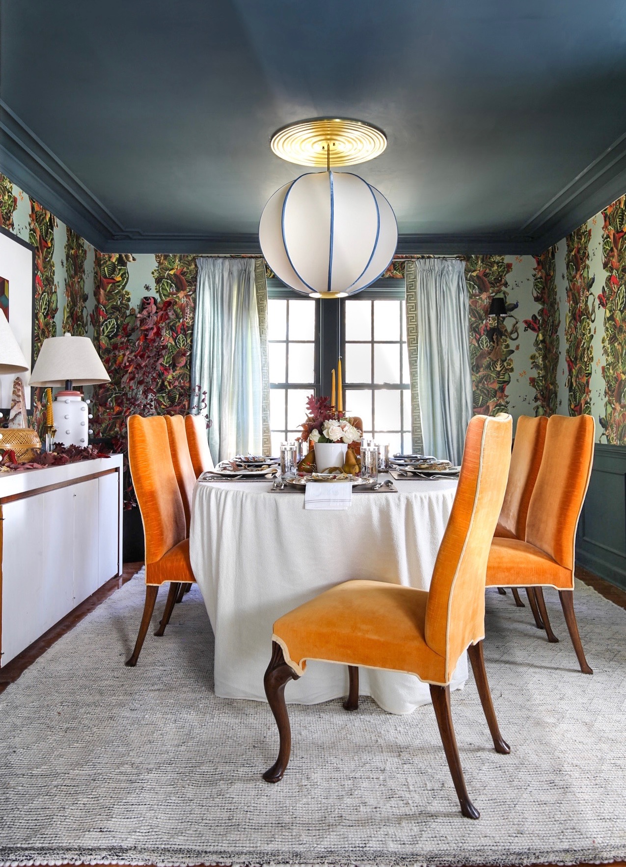 maximalist decor, maximalist dining room, jungle wallpaper, wallpaper, just rug, over scaled chandelier, dining room, dupioni silk drapes, glamorous dining room, milo baughman chairs, inchyra blue, farrow and ball, 